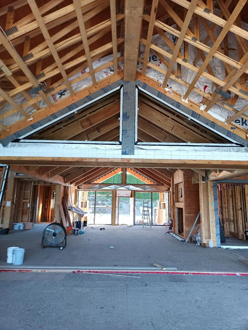 Interior of a timber-framed house with gable glazing set into the truss line